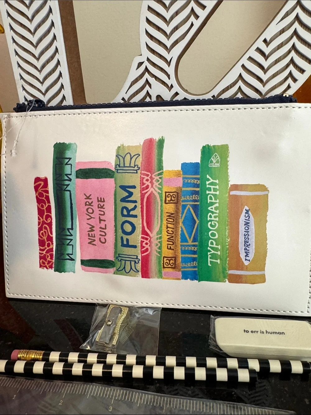 kate spade white pouch with colorful book spine print